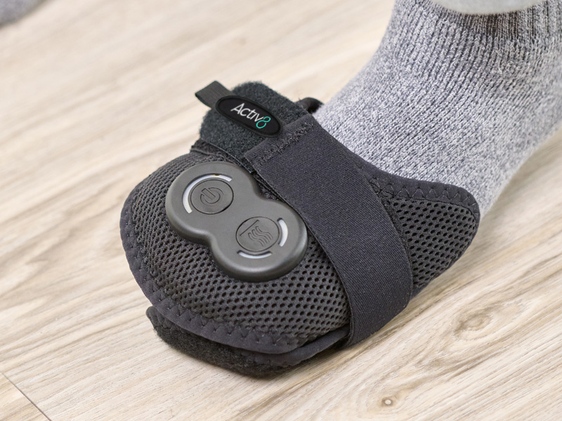 Person wearing the Activ8 Foot device on the front half of their foot, targeting pain near the toes.